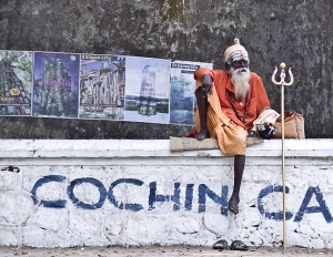 A Sadhu rests on a wall in Cochin.